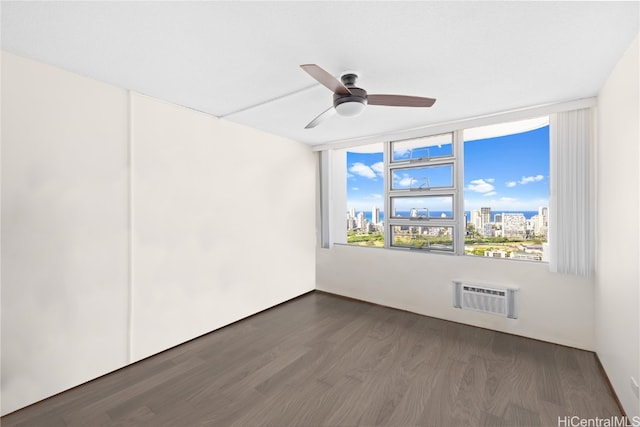 empty room featuring a wall mounted air conditioner, ceiling fan, and dark wood-type flooring