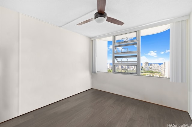 unfurnished room with ceiling fan and dark hardwood / wood-style flooring