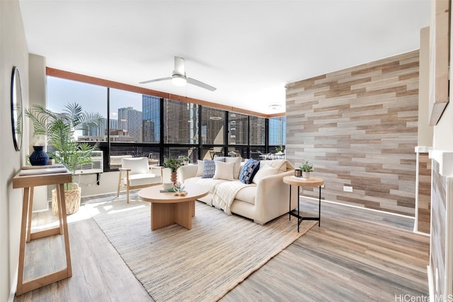 living room with floor to ceiling windows, ceiling fan, and wood-type flooring