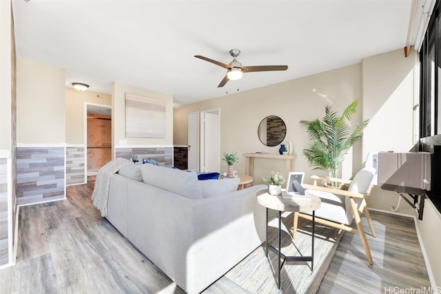 living room featuring ceiling fan and light hardwood / wood-style flooring