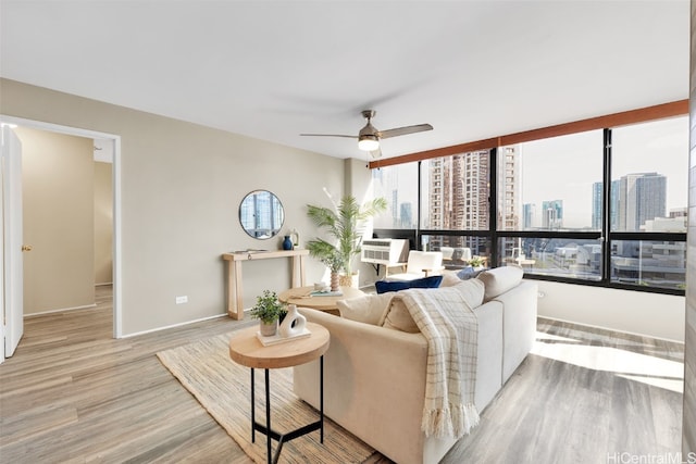 living room featuring ceiling fan and light hardwood / wood-style floors