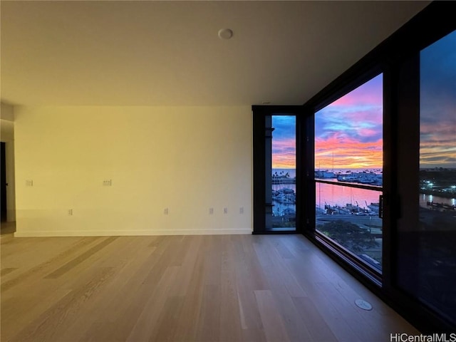 empty room with wood-type flooring and a water view