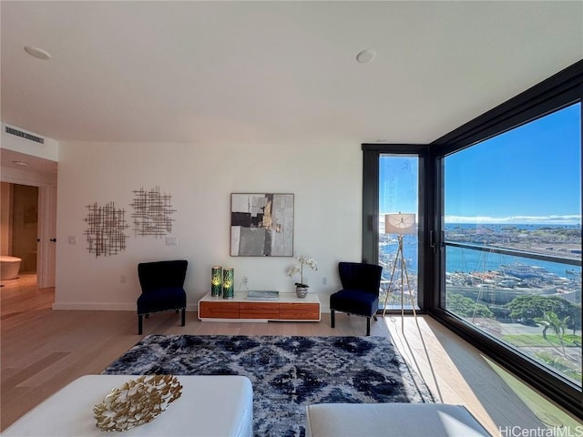 living room with a water view, plenty of natural light, and hardwood / wood-style flooring