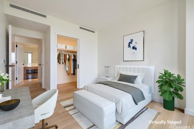 bedroom featuring light hardwood / wood-style floors, a spacious closet, and a closet