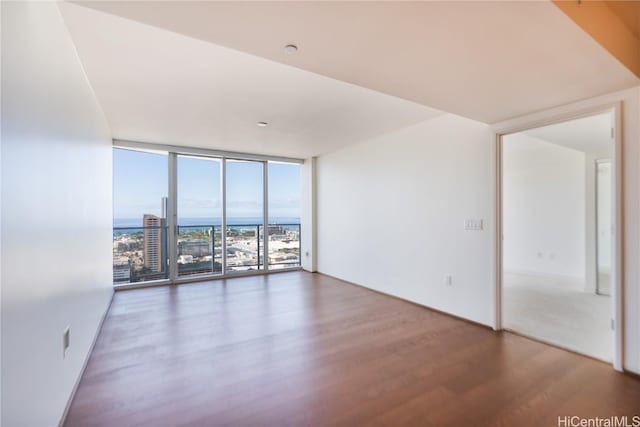 unfurnished room featuring hardwood / wood-style flooring and floor to ceiling windows