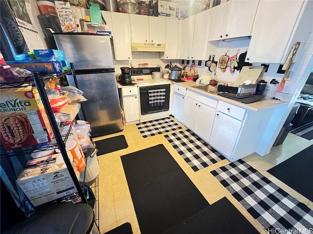 kitchen with white cabinetry, backsplash, white range, and stainless steel fridge