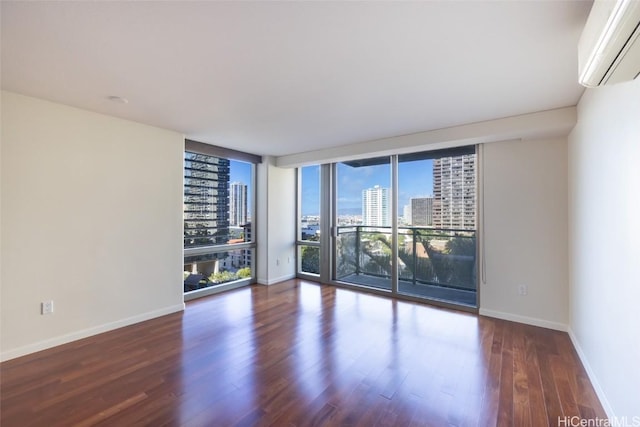 unfurnished room featuring expansive windows, dark hardwood / wood-style flooring, and an AC wall unit