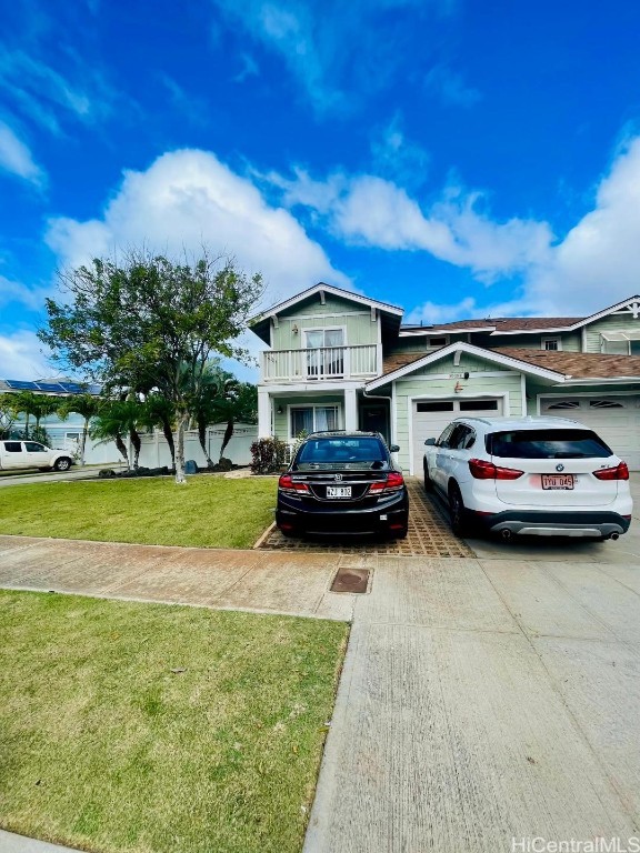 view of front of home with a front lawn, a balcony, and a garage