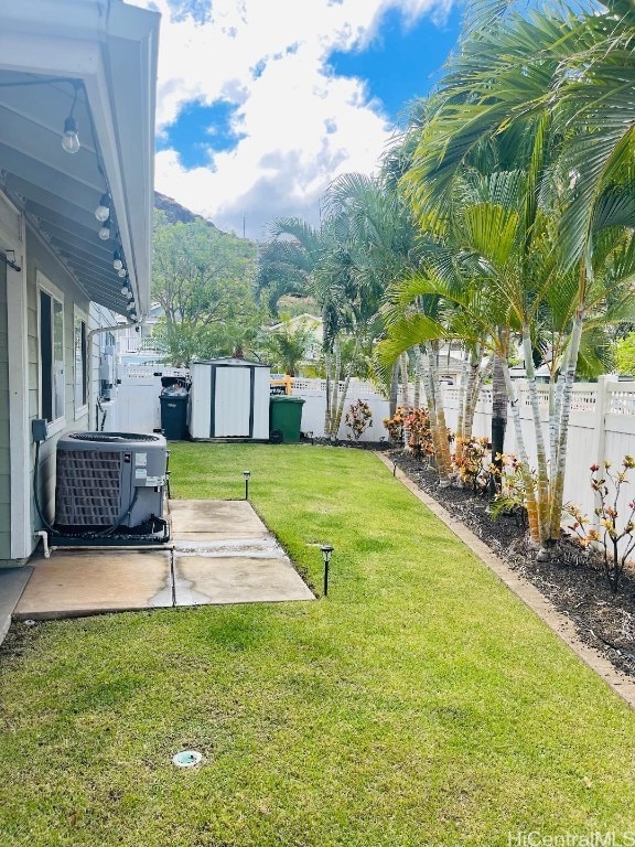 view of yard featuring a storage shed, central air condition unit, and a patio area