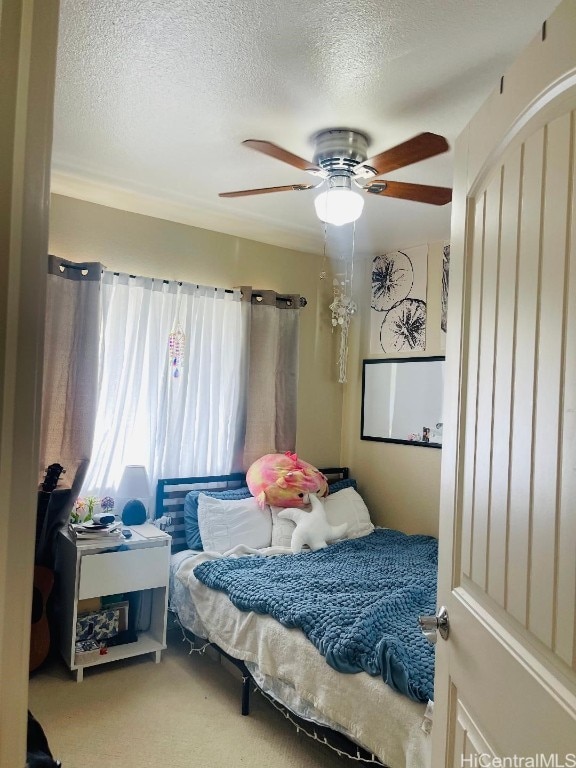 carpeted bedroom with a textured ceiling and ceiling fan