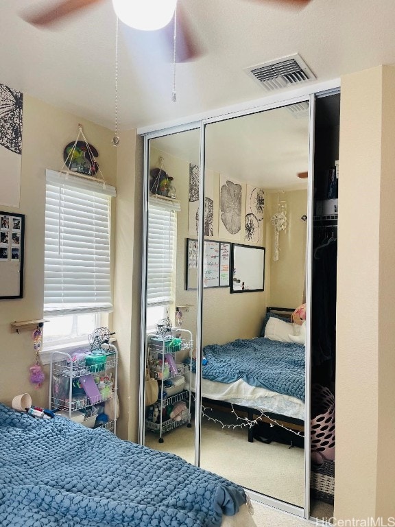 carpeted bedroom featuring ceiling fan and a closet