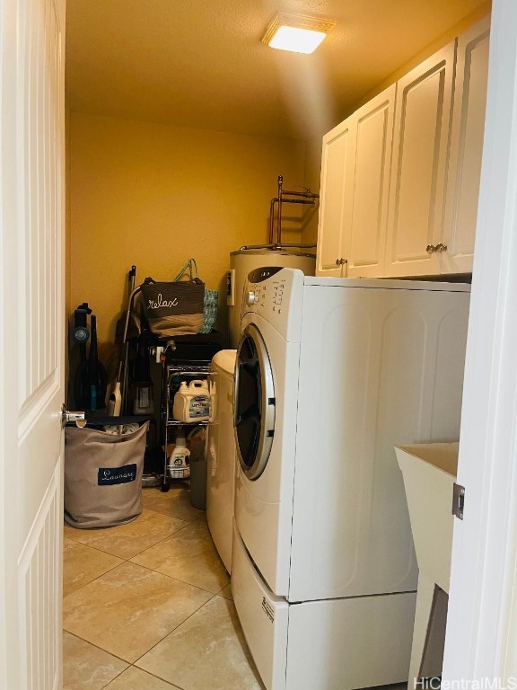 washroom with cabinets, light tile patterned flooring, and washer and clothes dryer