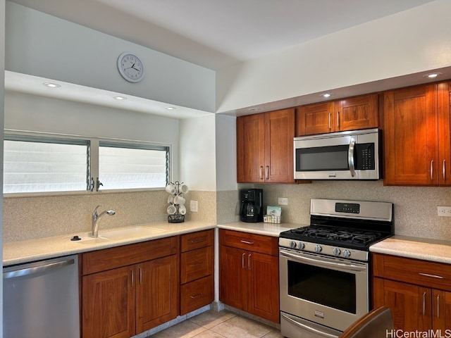 kitchen with tasteful backsplash, appliances with stainless steel finishes, sink, and light tile patterned flooring