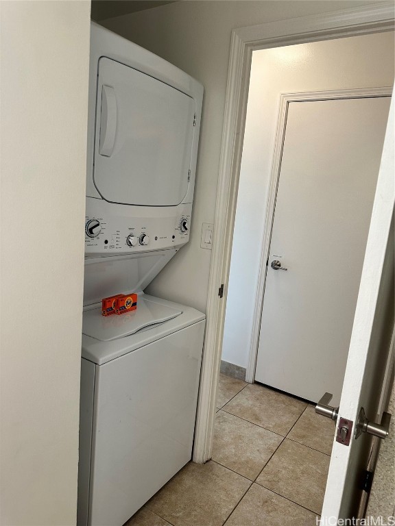 washroom featuring stacked washing maching and dryer and light tile patterned floors