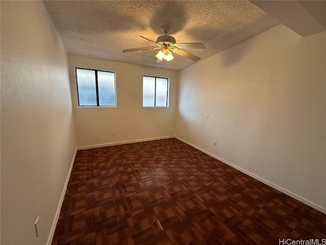 unfurnished room featuring a textured ceiling, ceiling fan, and dark parquet floors