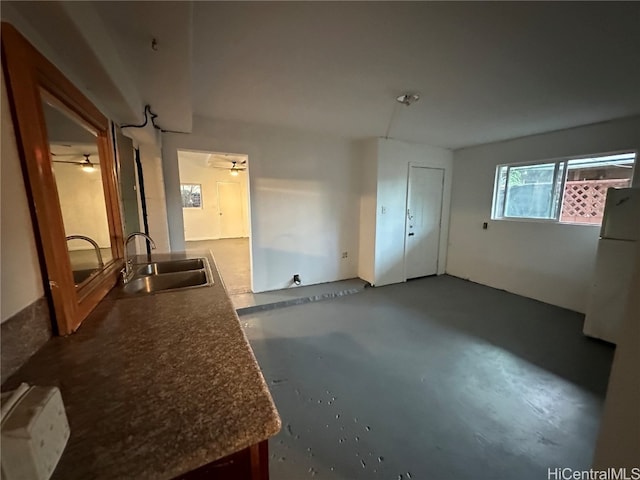 empty room featuring sink, ceiling fan, and concrete floors