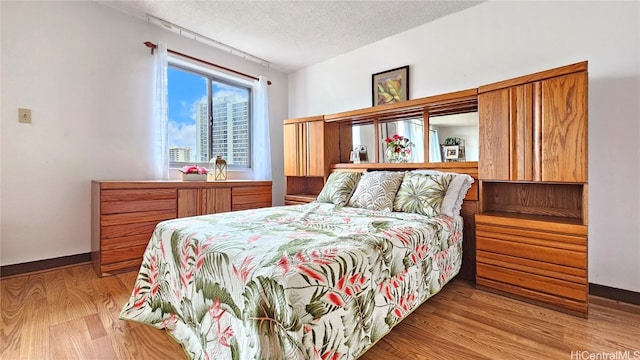 bedroom featuring light wood-type flooring and a textured ceiling