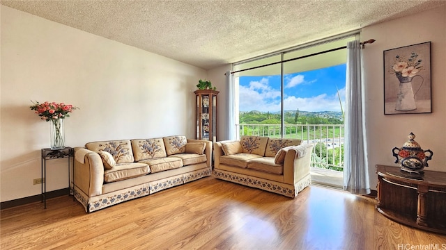 living room featuring expansive windows, wood-type flooring, and a textured ceiling