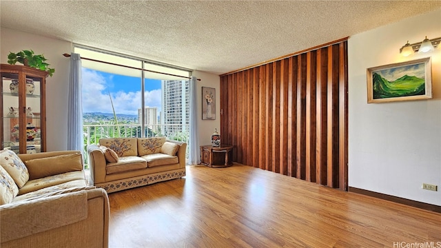 living room with floor to ceiling windows, wood-type flooring, and a textured ceiling