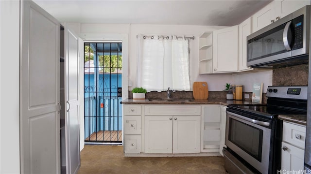 kitchen featuring appliances with stainless steel finishes, sink, and white cabinets