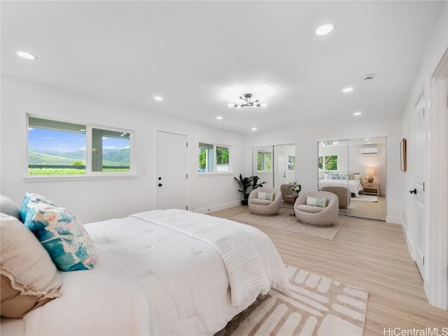 bedroom featuring a wall unit AC and light wood-type flooring