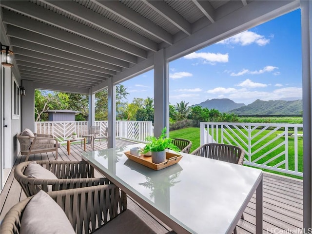 wooden deck with a mountain view and a lawn