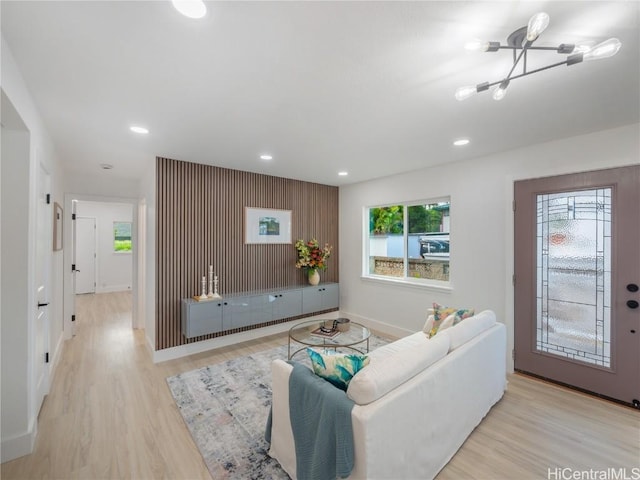 living room featuring light wood-type flooring and a notable chandelier