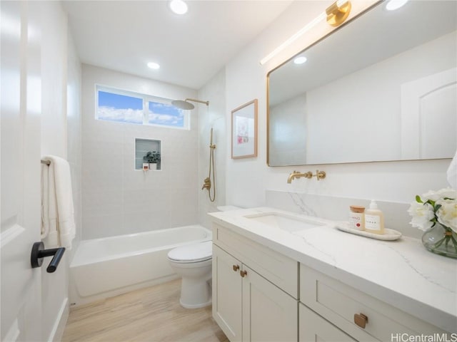 full bathroom featuring vanity, hardwood / wood-style flooring, toilet, and tiled shower / bath