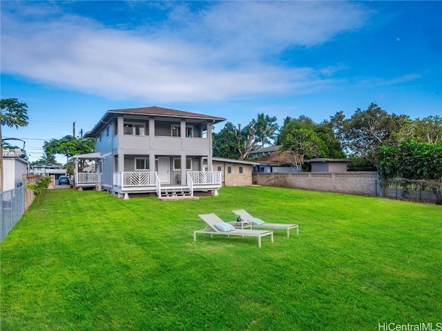 rear view of house featuring a yard and a wooden deck