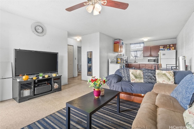 living room featuring ceiling fan and sink