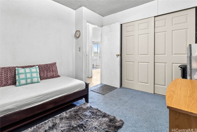 carpeted bedroom with a closet and a textured ceiling