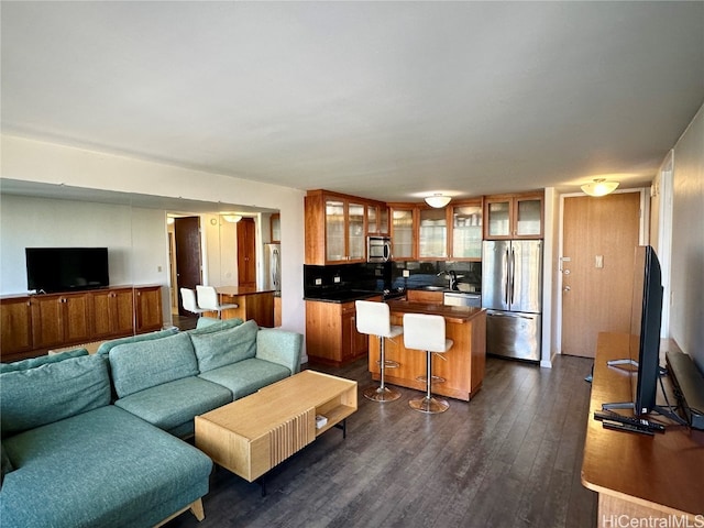 living room featuring sink and dark hardwood / wood-style floors