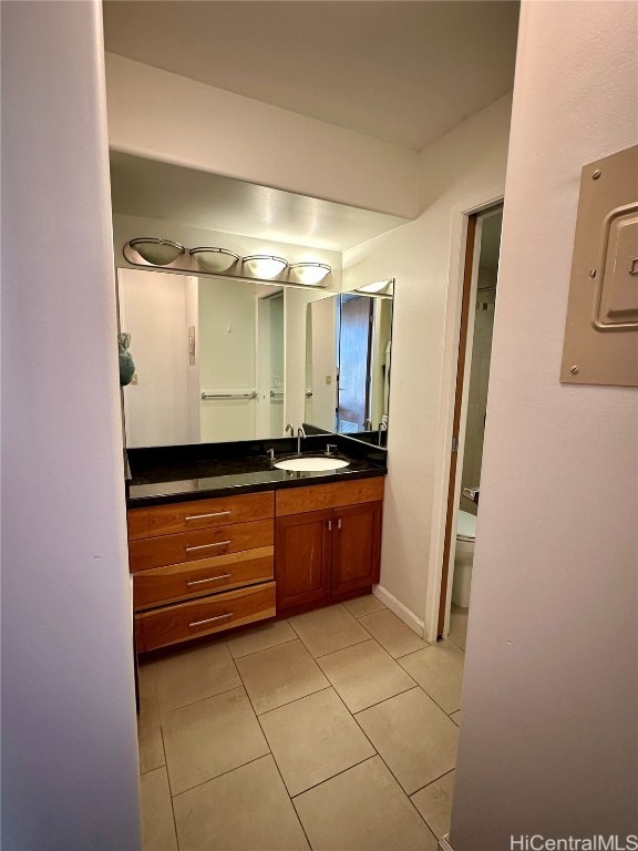 bathroom featuring tile patterned floors, electric panel, vanity, and toilet