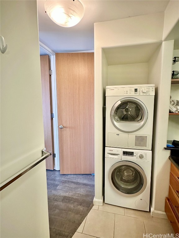 washroom with stacked washer and dryer and light hardwood / wood-style floors