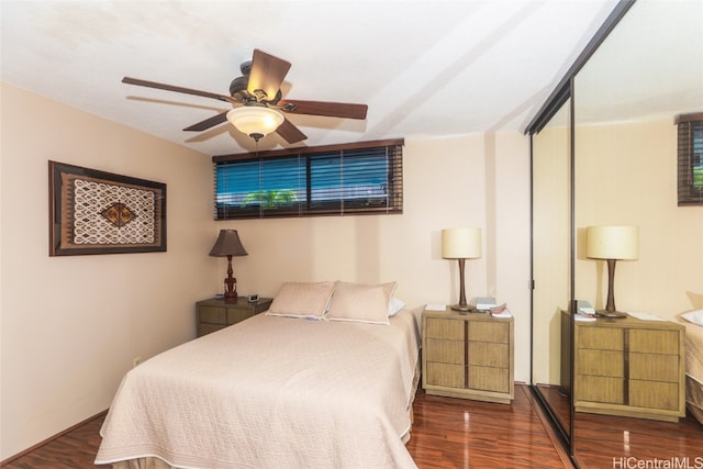 bedroom with ceiling fan, dark wood-type flooring, and a closet