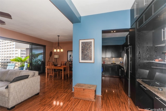 living room featuring dark hardwood / wood-style floors and an inviting chandelier