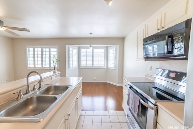 kitchen featuring stainless steel range with electric stovetop, sink, ceiling fan, light hardwood / wood-style flooring, and decorative light fixtures