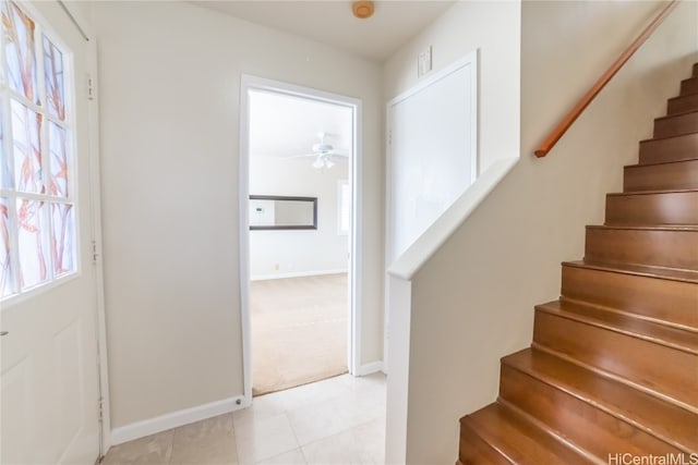 stairway featuring tile patterned floors, ceiling fan, and plenty of natural light