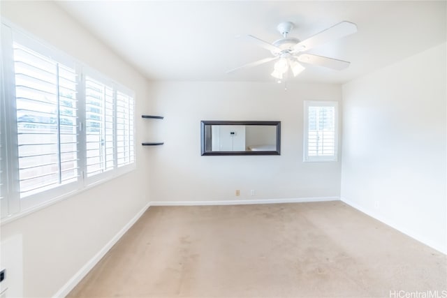 unfurnished room with light colored carpet and ceiling fan