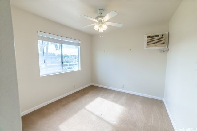 empty room with an AC wall unit, light colored carpet, and ceiling fan