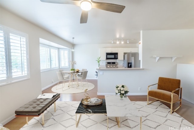 living area featuring light hardwood / wood-style floors and ceiling fan