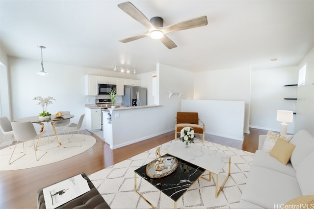 living room with ceiling fan and light hardwood / wood-style floors