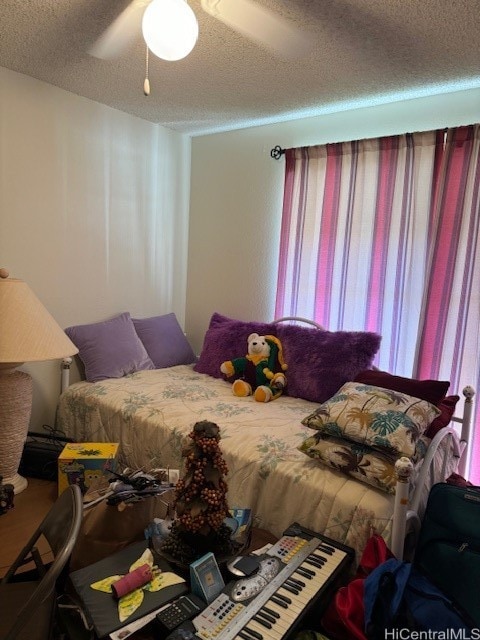 bedroom featuring ceiling fan and a textured ceiling