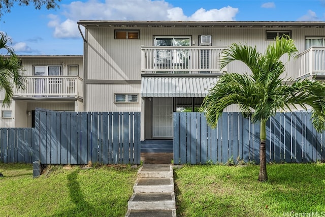 view of property featuring a front yard and a balcony