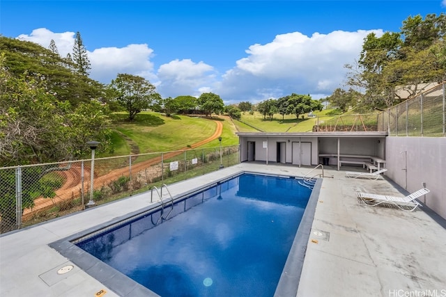 view of pool with a patio and a yard