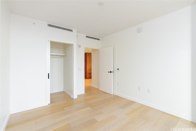 unfurnished bedroom featuring a closet and light wood-type flooring