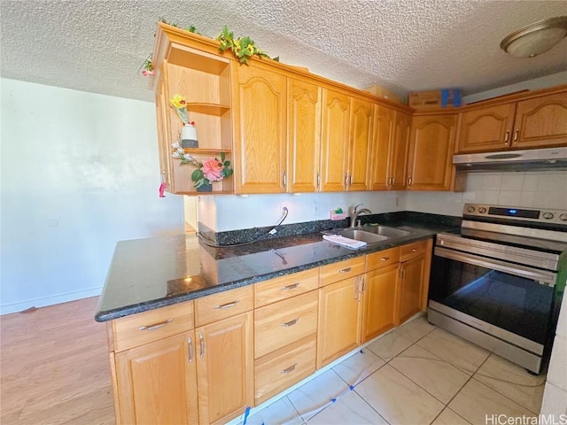 kitchen featuring sink, dark stone countertops, electric range, a textured ceiling, and kitchen peninsula