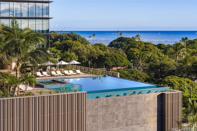 view of swimming pool with a water view and a patio area