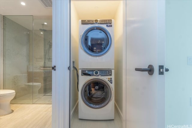 washroom featuring hardwood / wood-style floors and stacked washer / dryer