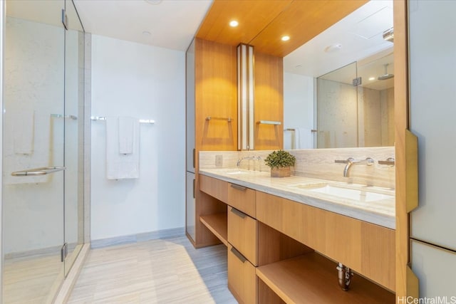 bathroom with wood-type flooring, vanity, an enclosed shower, and tasteful backsplash